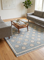 Close-up of cream star pattern on blue handmade wool rug